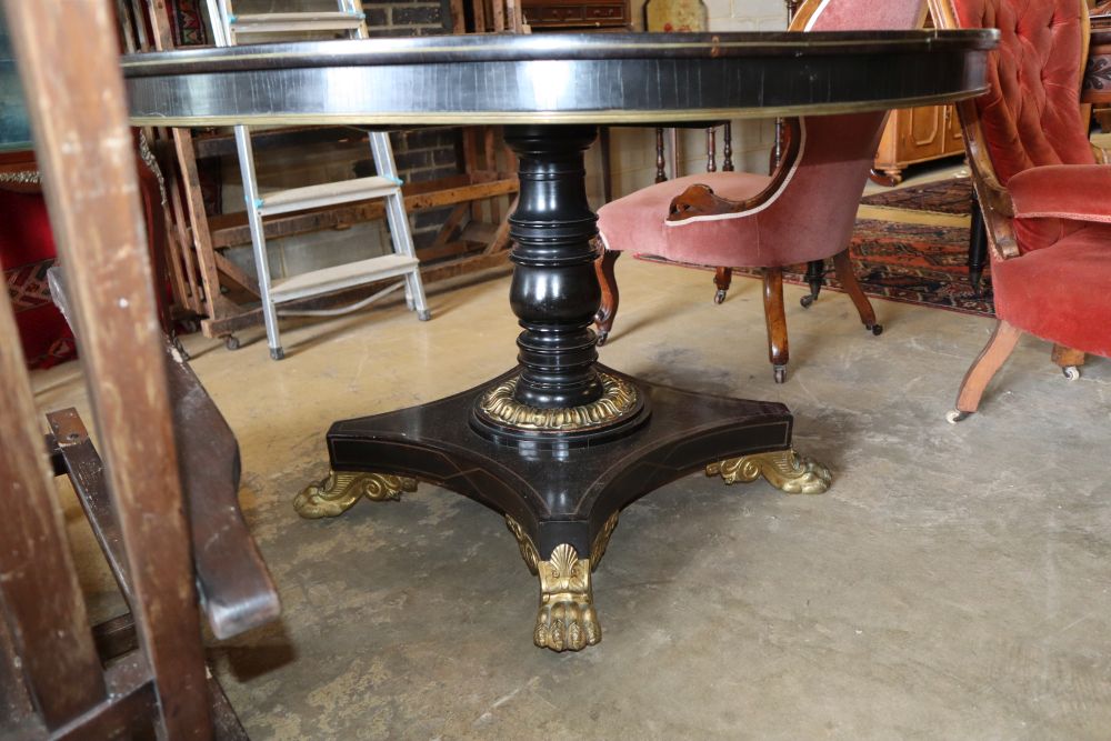 A George IV rosewood and ebonised gilt metal mounted circular breakfast table, on cast lion paws feet, diameter 121cm, H.74cm
